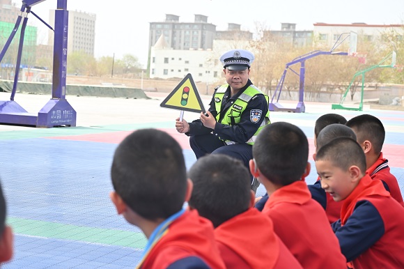 4月14日，轮台县公安局交警大队民警借助交通安全标识引导学生们树牢交通安全意识。比拉力·艾力摄.JPG